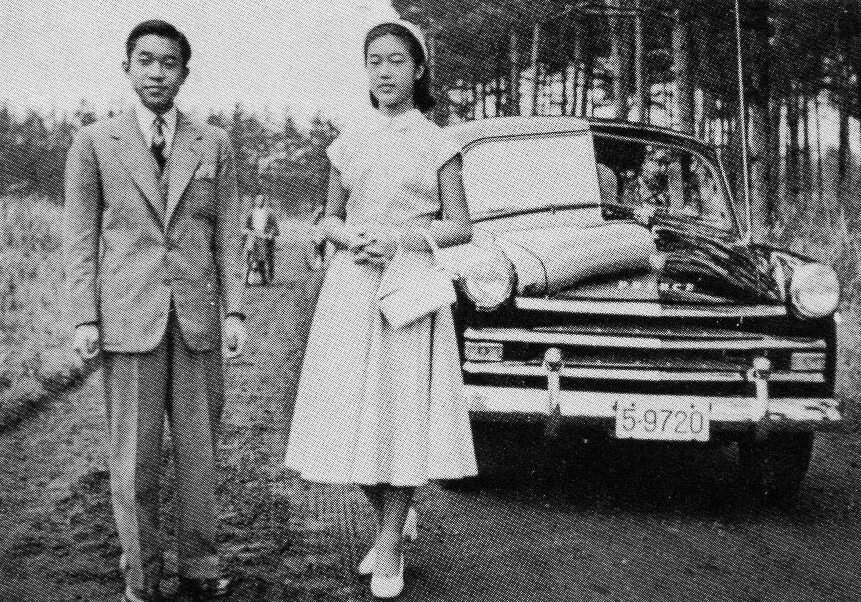 Exact 1954 Prince Sedan AISH-II, period black-and-white image; people partially obscure the front, but the body is identifiable.