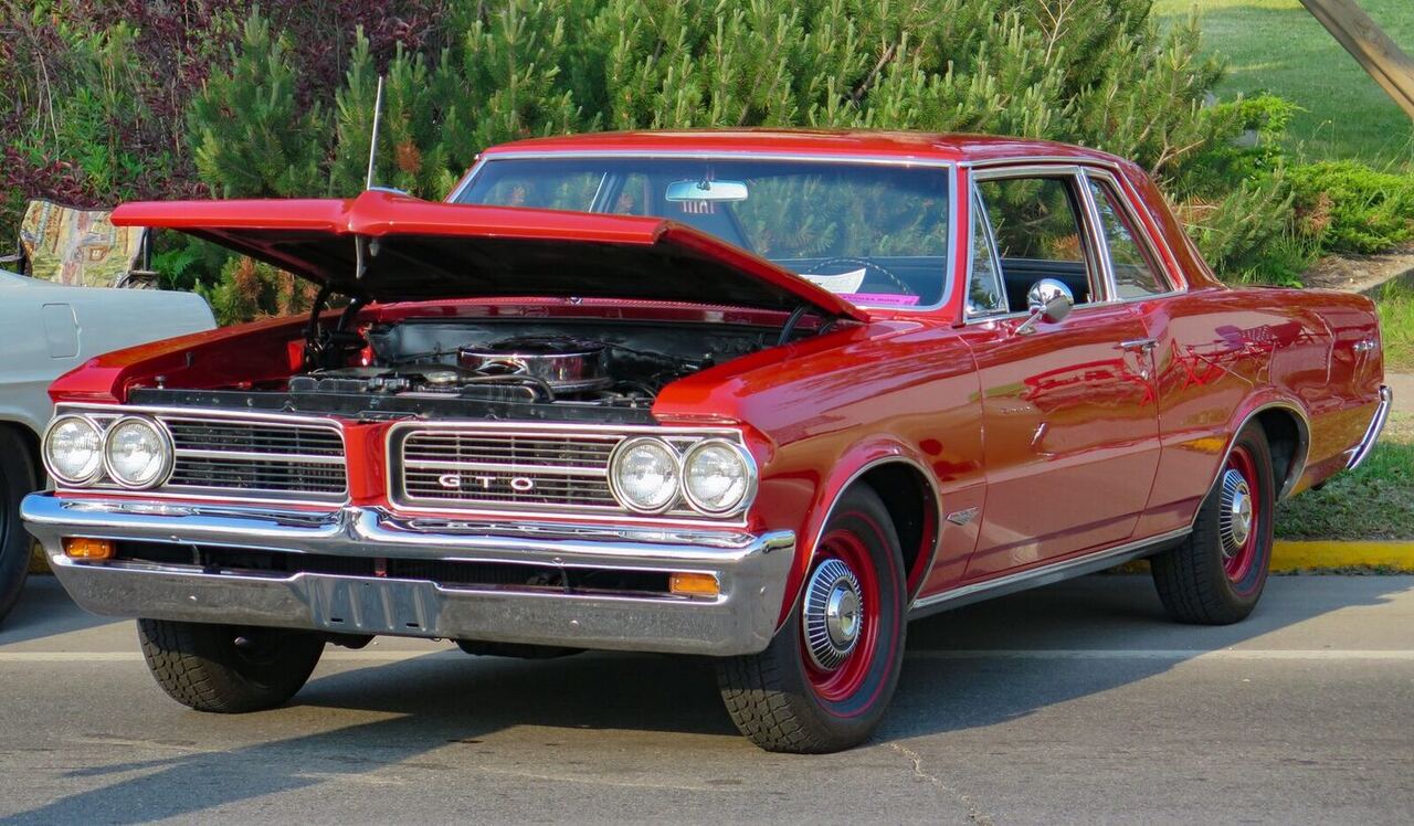 Exact 1964 pillared Sports Coupe body; 325-hp four-barrel engine and four-speed transmission are not visible, so the cover is representative for that mechanical configuration.