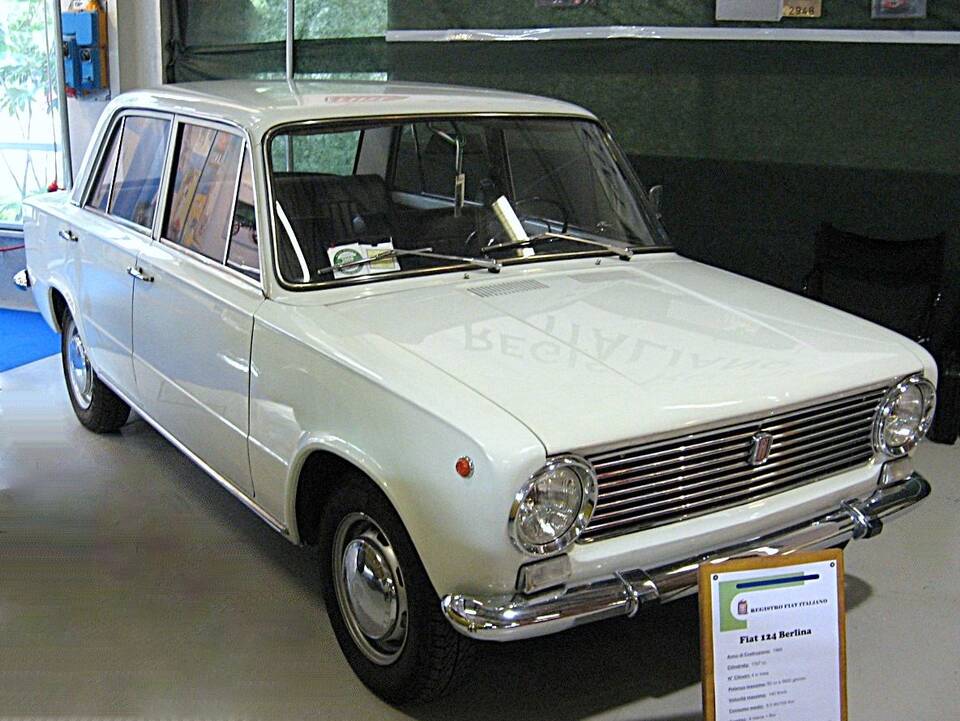 Commons describes the car as a 1966 first-series Fiat 124 and the display sign identifies a 124 Berlina. The photograph does not independently prove its exact engine or gearbox.