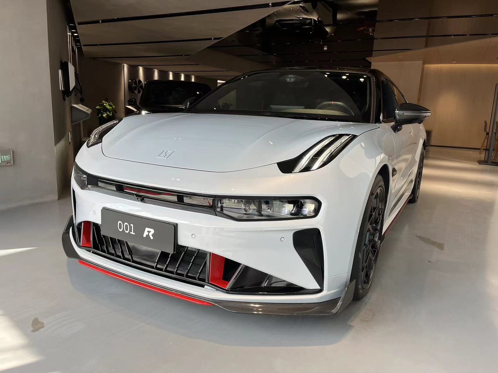 Representative pre-facelift Zeekr 001 FR photographed on 13 February 2024, with visible 001 FR plate, carbon-fiber front splitter and red aero details. Not a 2023 launch press photograph; the exterior cannot verify its software, power rating or acceleration configuration.