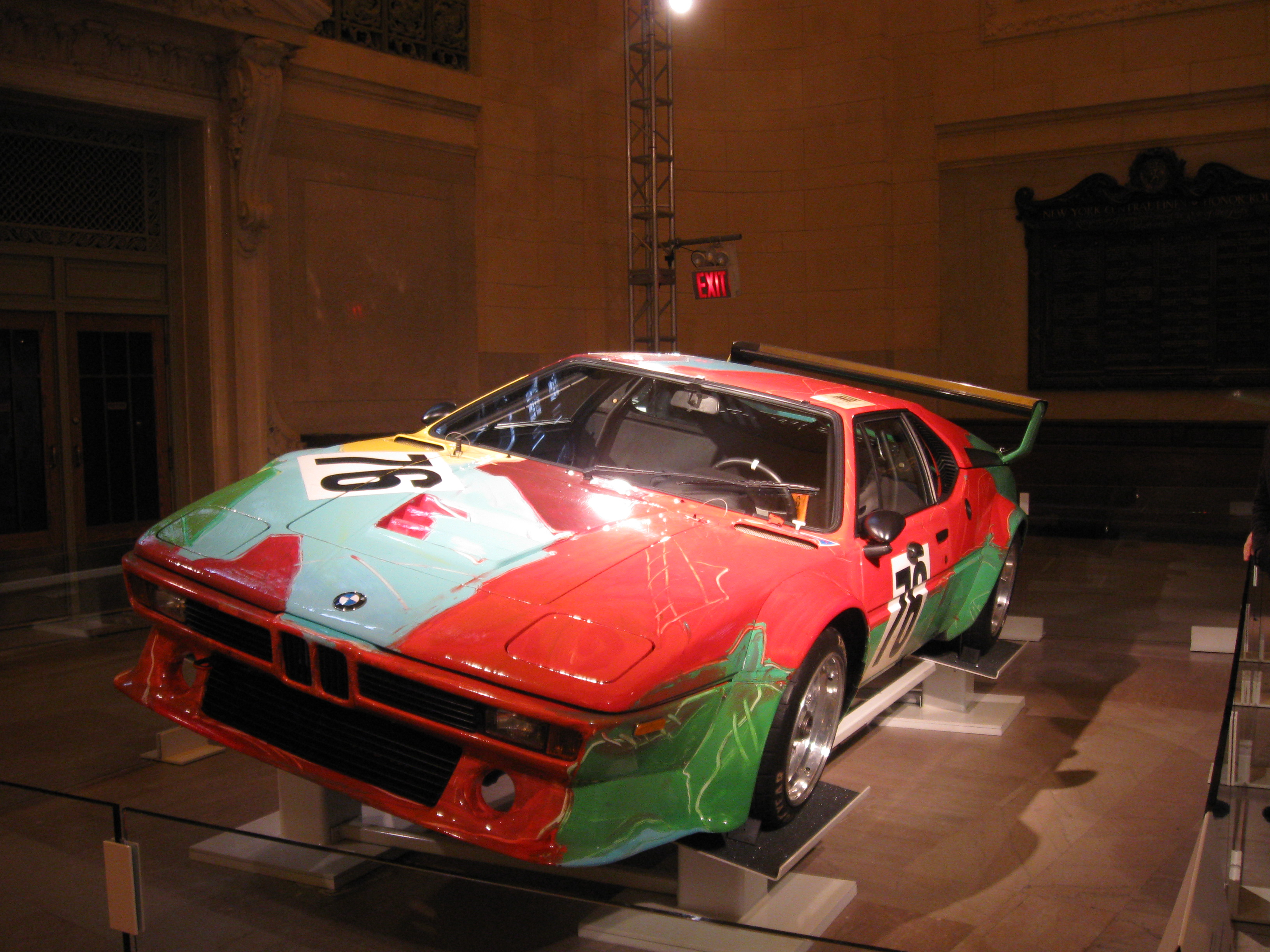 Andy Warhol’s red, green and blue BMW M1 Group 4 Art Car no. 76 displayed indoors.