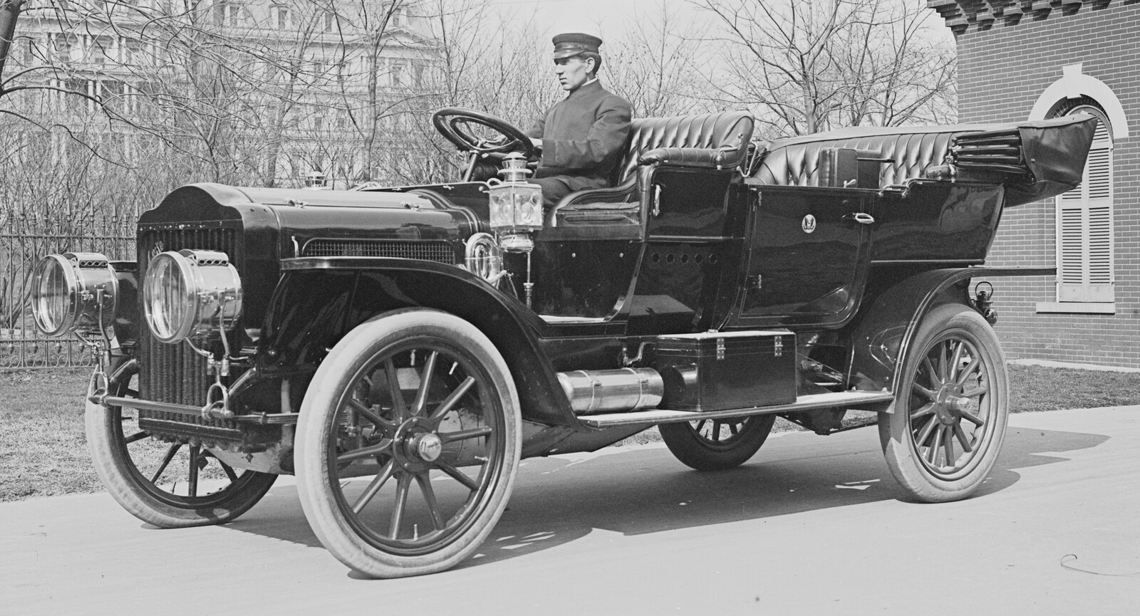 Black-and-white March 1909 photograph of the individual White Model M steam touring car on White House grounds, viewed from the left with one unidentified driver aboard.