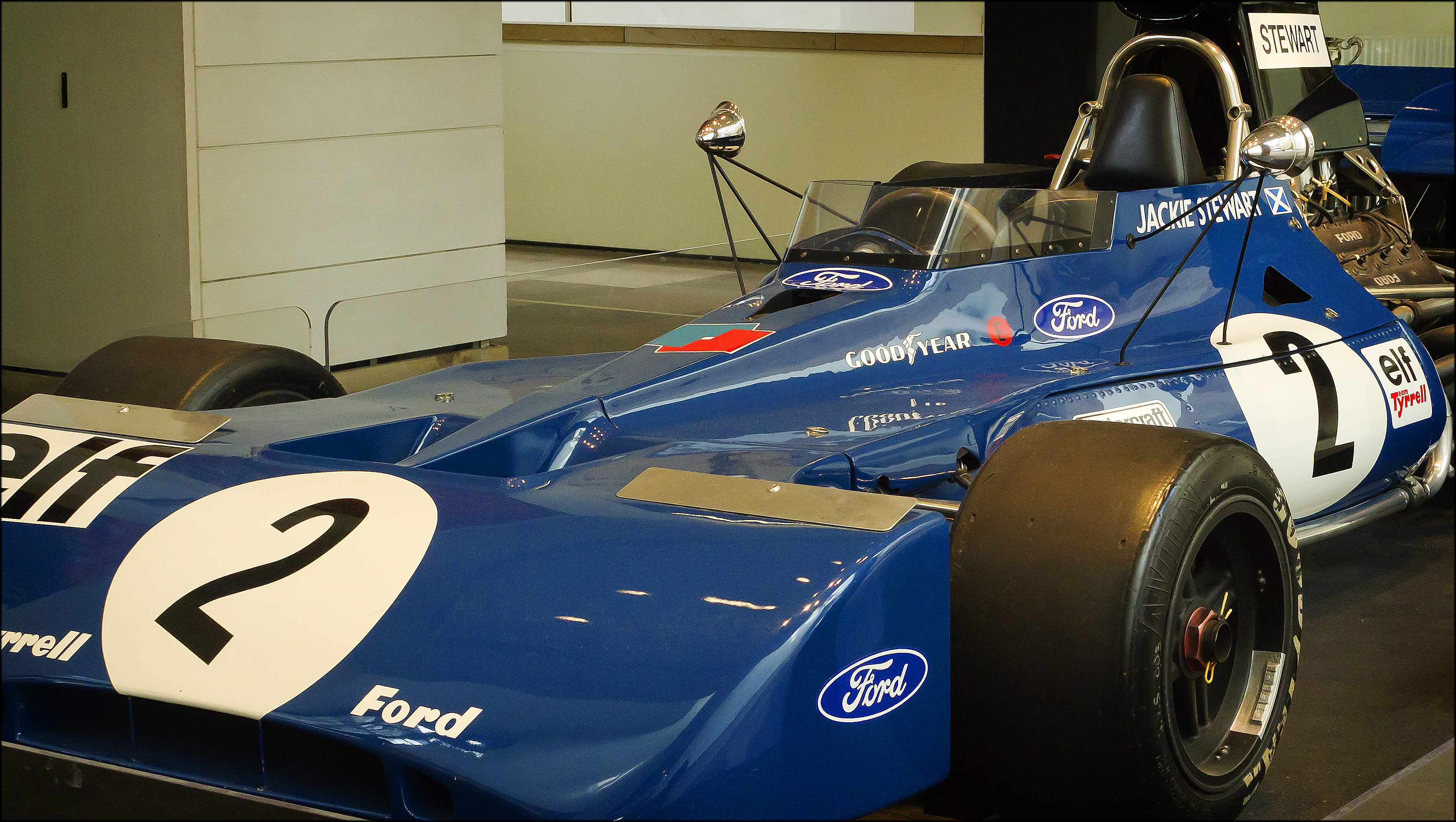 The actual blue Tyrrell 003 Formula One car with white number 2 displayed indoors at the National Museum of Scotland.