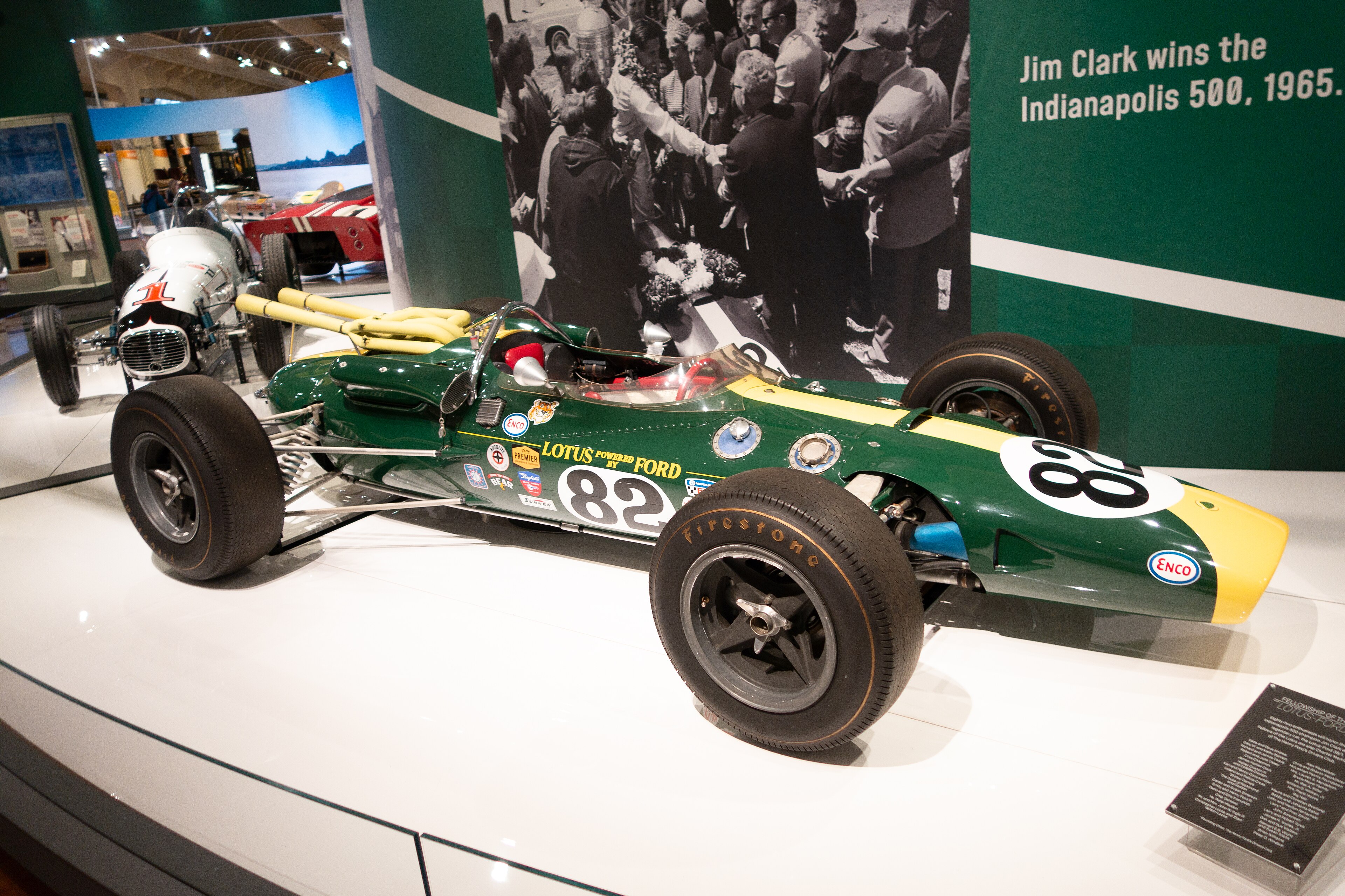 Green-and-yellow Lotus-Ford number 82 displayed at The Henry Ford beneath a wall identifying Jim Clark’s 1965 Indianapolis 500 victory.