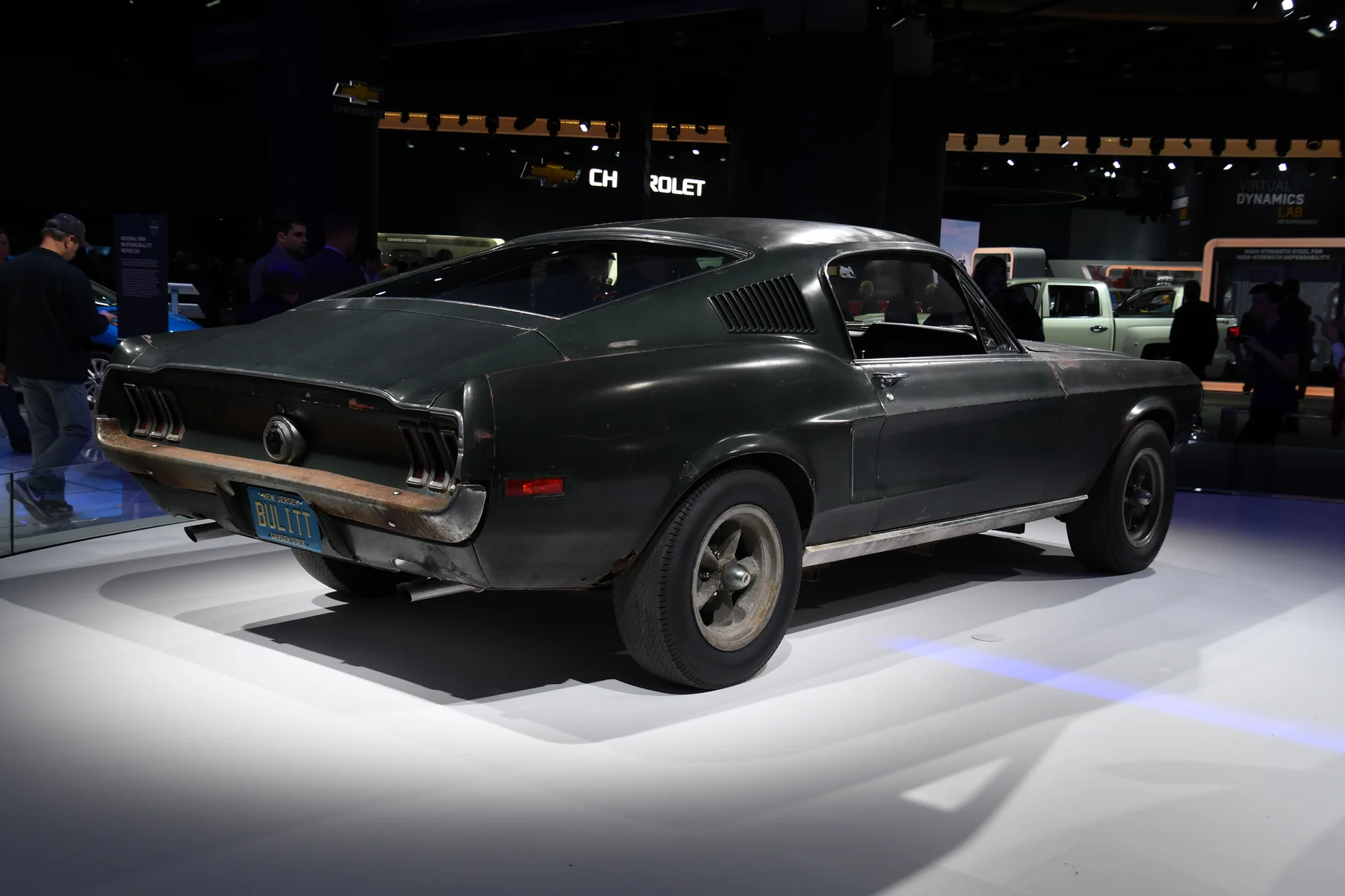 The unrestored dark green Bullitt hero Mustang, seen from the rear right at the 2018 Detroit auto show.
