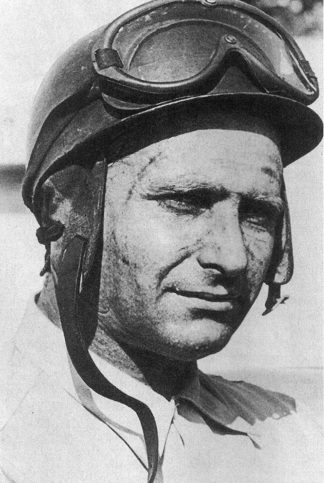 Juan Manuel Fangio wearing a racing helmet and goggles in a circa-1952 identification portrait.