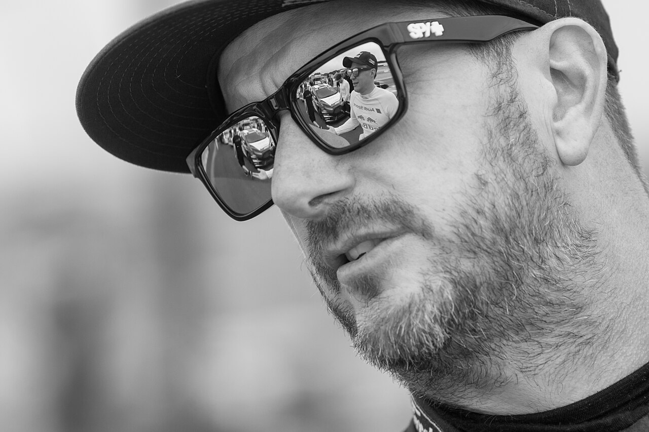 Black-and-white close portrait of Ken Block wearing a cap and sunglasses at the 2017 World RX of South Africa.