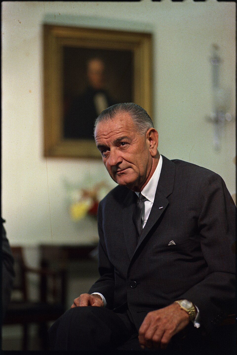 President Lyndon B. Johnson seated in a dark suit in a 1965 White House portrait by Yoichi Okamoto.