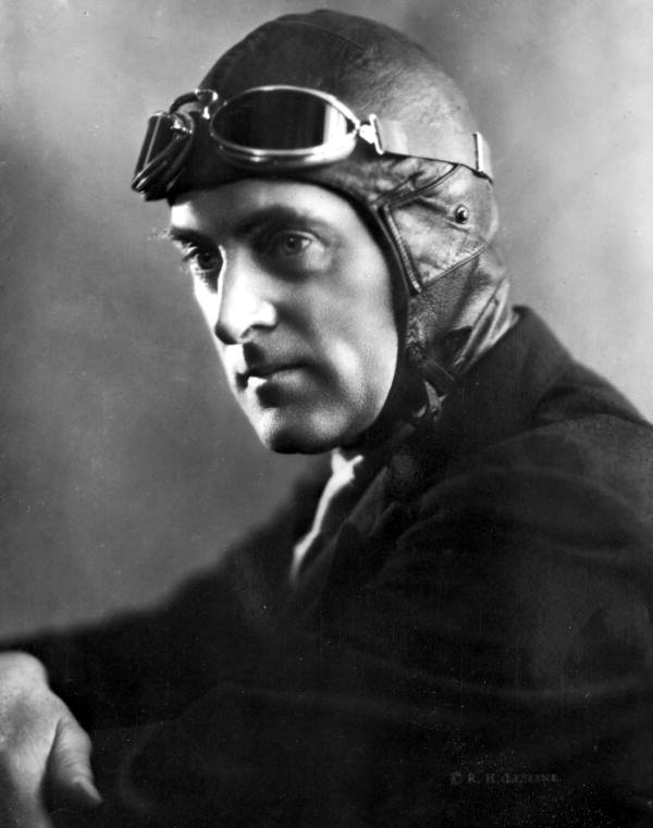 Black-and-white studio portrait of Sir Malcolm Campbell wearing a leather racing cap and goggles, photographed by Richard LeSesne.