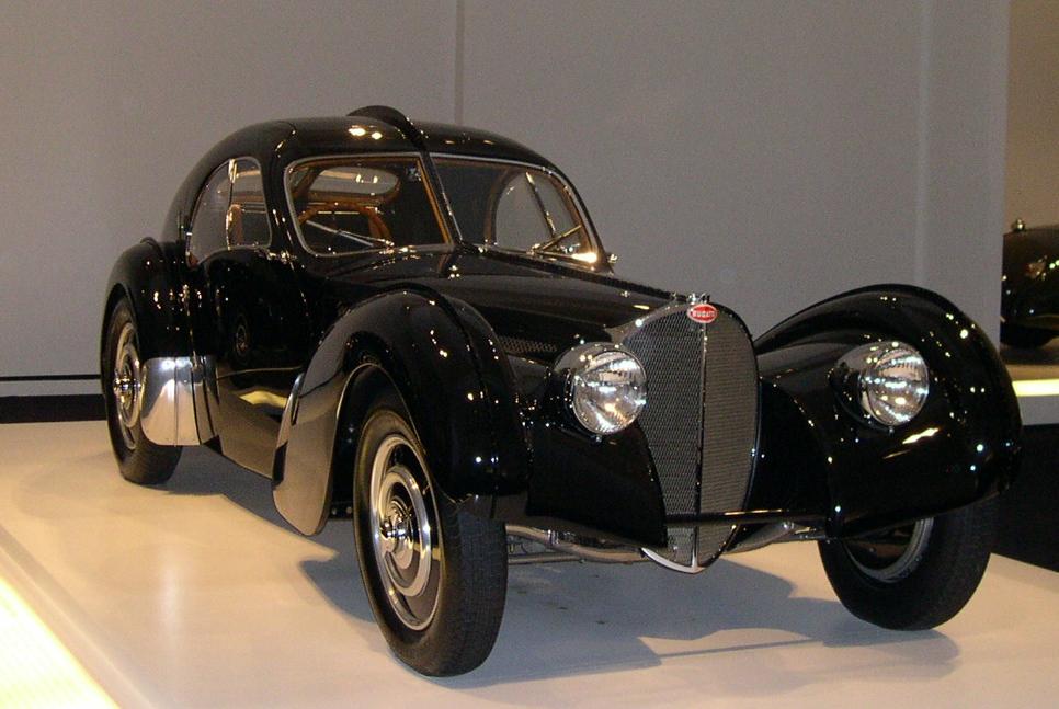 Ralph Lauren’s black 1938 Bugatti Type 57 SC Atlantic, chassis 57 591, displayed on a white museum platform.