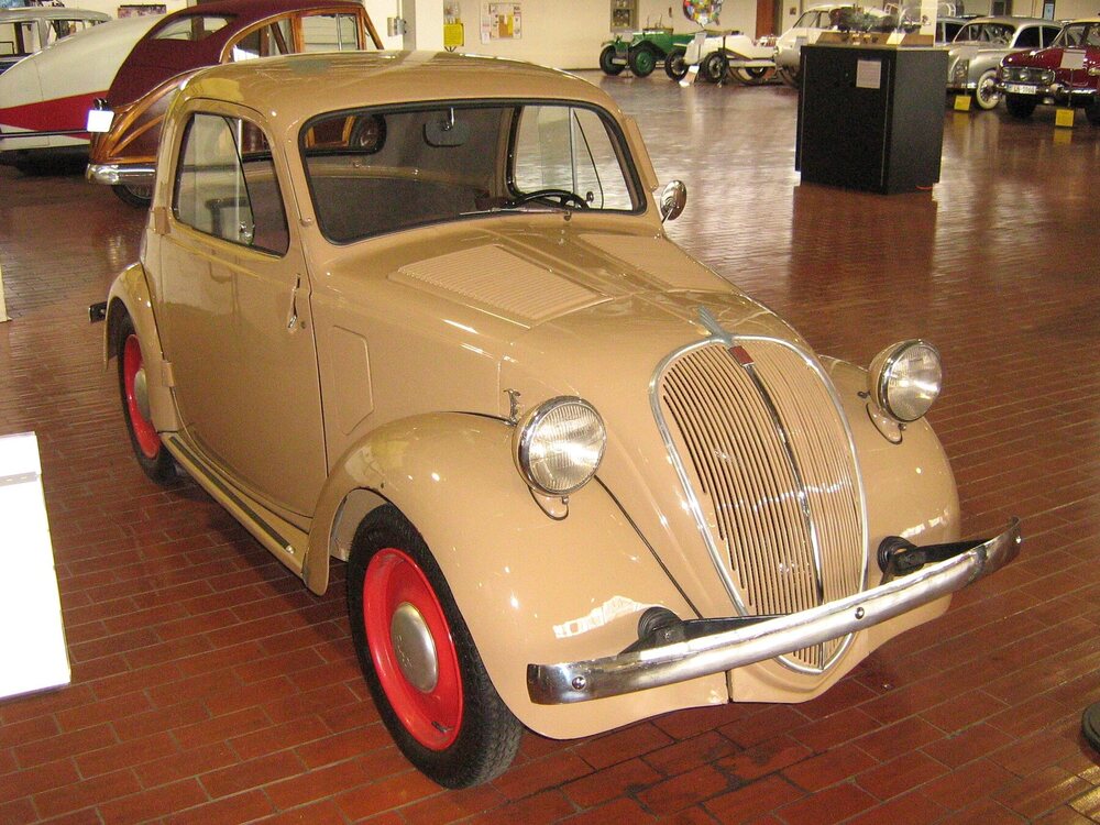 Wikimedia Commons identifies the Lane Motor Museum car as a 1936 Fiat 500 Coupe Topolino.