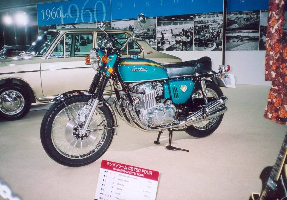 Honda Dream CB750 Four K0, turquoise/blue motorcycle in a museum; display placard gives model year 1969.