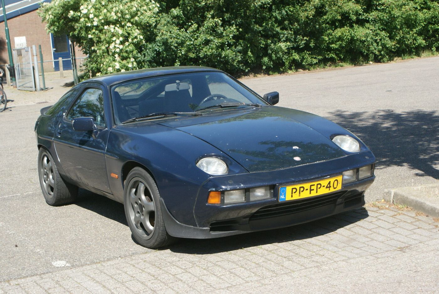 The photograph is an exact 1978 Porsche 928 with European registration, but it has the optional automatic transmission while the profile follows the five-speed manual. Its wheels also appear to be later replacements.