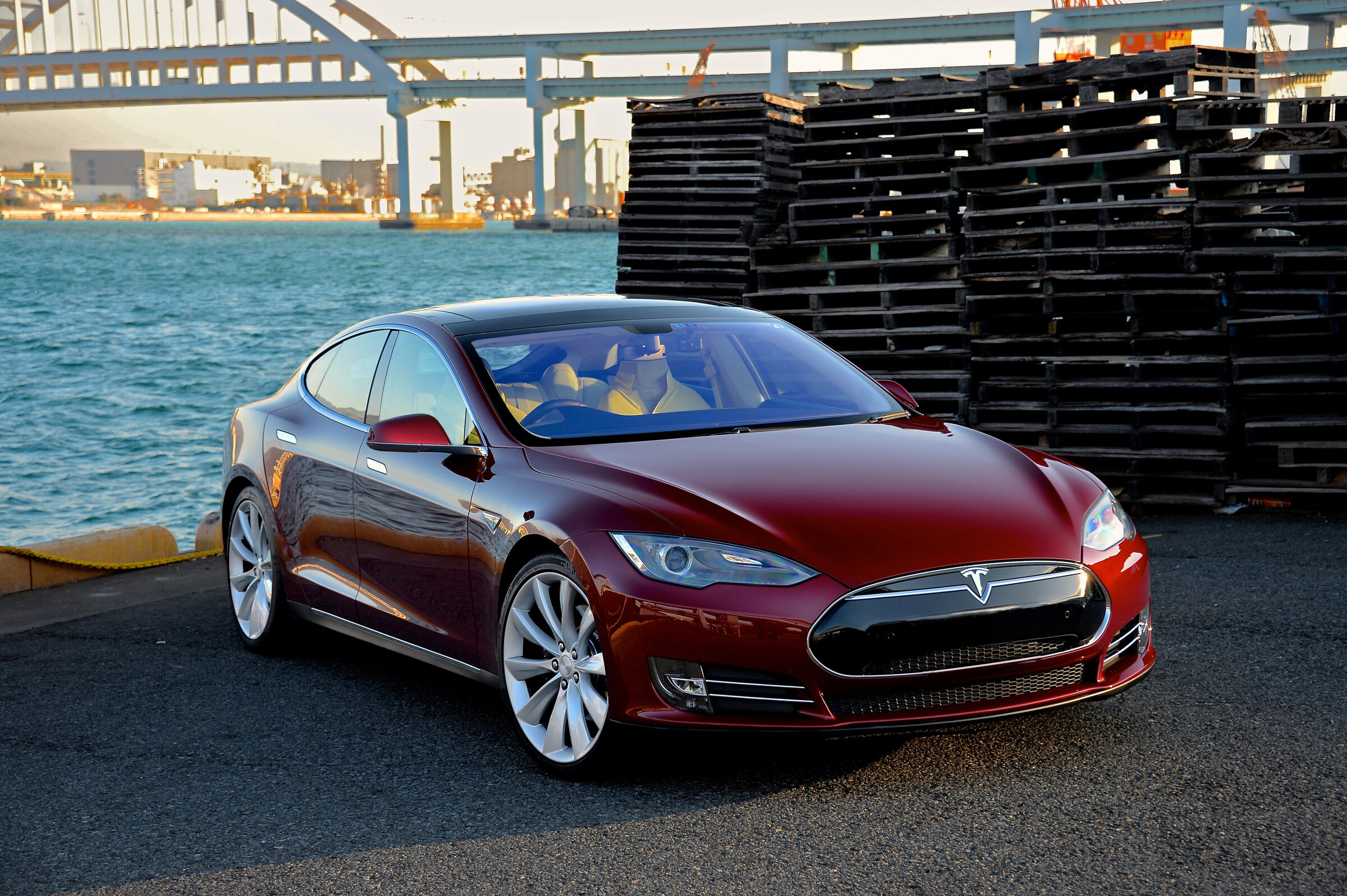 first-generation Model S photographed in Signature Red; Signature Performance and 2012 model year not independently established. Cover scope: early Model S in Signature Red; performance variant unverified.